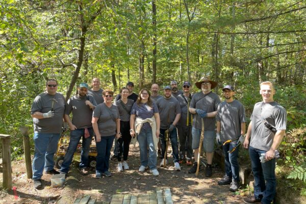 Members of the WIN Team holding tools for yard work as they volunteer at the annual United Way Day of Caring.