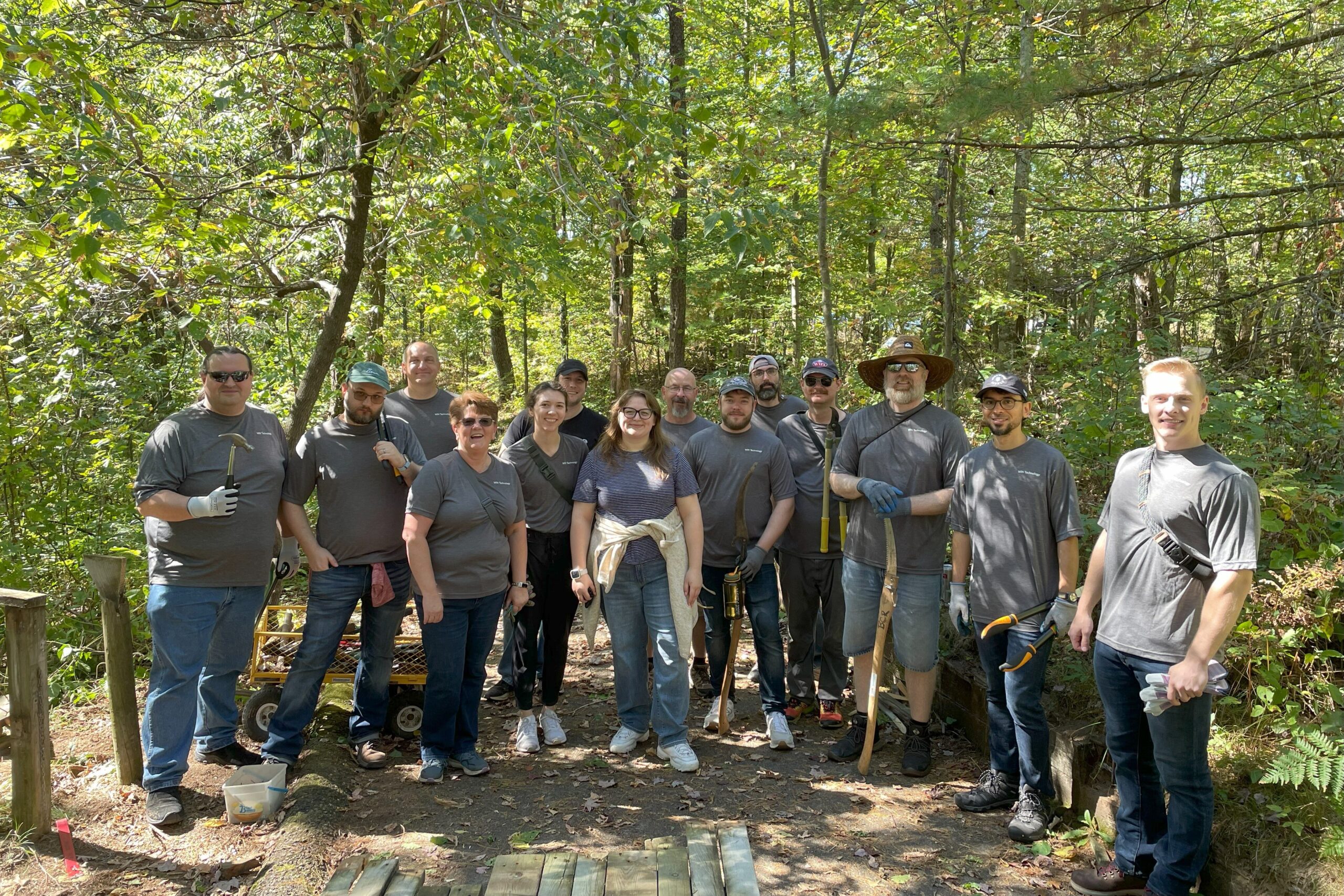 Members of the WIN Team holding tools for yard work as they volunteer at the annual United Way Day of Caring. 